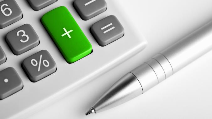 Lower right corner of a gray calculator, with a green plus sign and a pen underneath
