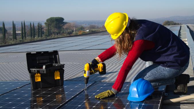 Skilled woman fitting a photovoltaic panel