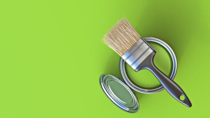 Concept of a green bucket of paint and paintbrush.
