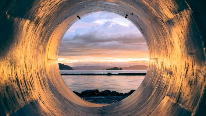 The inside of a pipe looking out into the sea