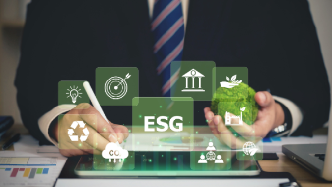 man in suit sitting at desk with different icons floating in the air such as the recycling symbol, an ESG sign, a lightbulb, and more